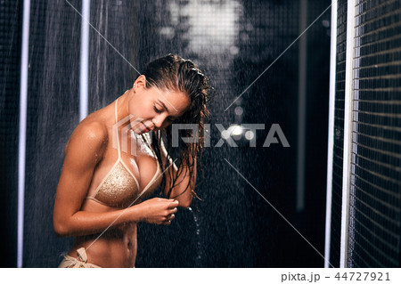 Beautiful caucasian brunette woman taking shower in her black luxury bathroom. Beautiful caucasian brunette woman taking shower in her black luxury bathroom. 44727921