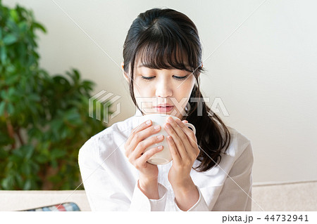 温かい飲み物を飲む女性の写真素材