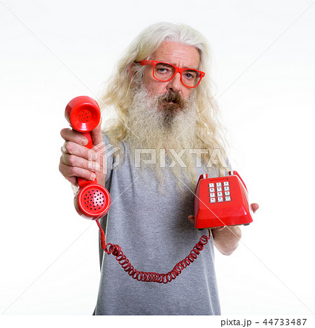 Studio shot of senior bearded man giving old telephone 44733487