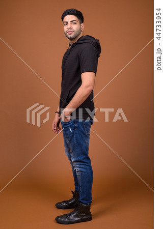Young handsome Indian man against brown background Young handsome Indian man against brown background 44733954