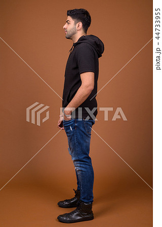 Young handsome Indian man against brown background 44733955