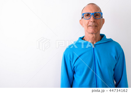 Studio shot of happy bald senior man smiling while wearing eyegl Studio shot of happy bald senior man smiling while wearing eyegl 44734162