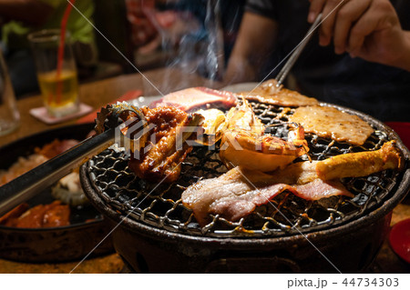 Group of people eating korean barbecue yakiniku Group of people eating korean barbecue yakiniku 44734303