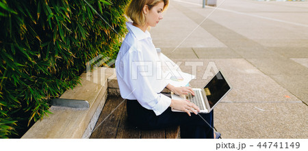 Close up face of woman typing with laptop outdoors. 44741149
