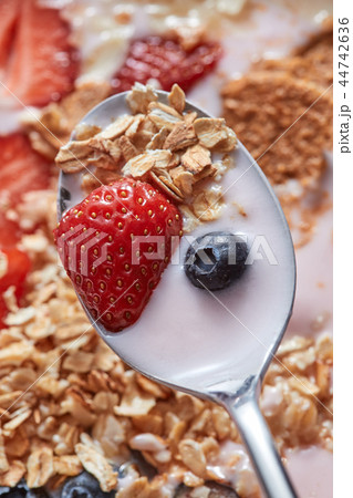 Close-up of spoon with fresh natural homemade morning breakfast with strawberries, milk dessert, oat Close-up of spoon with fresh natural homemade morning breakfast with strawberries, milk dessert, oat 44742636