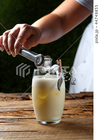 Female hand putting ice with tongs in a glass Female hand putting ice with tongs in a glass 44749855