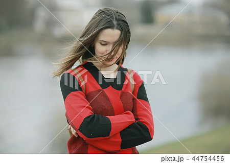 autumn sad girl outdoor / autumn weather, portrait of a young adult girl in a coat in a cage, Scottish style autumn sad girl outdoor / autumn weather, portrait of a young adult girl in a coat in a cage, Scottish style 44754456