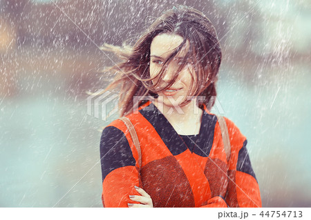 rainy weather girl posing fall / raindrops, spray, girl adult on a rain background 44754713