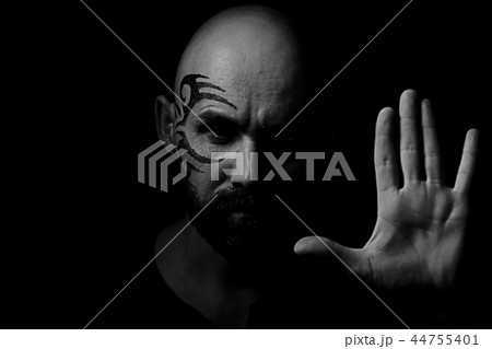 tattoo on the face, male portrait in the form of an assassin, cosplay, tattooed brutal man, guy with a tattooed face 44755401