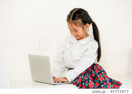 Little kid using laptop computer on white sofa. 44755977