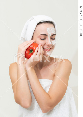 Woman get facial mask with tomato cream extract. 44756341