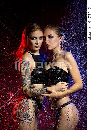 Two sexy tattooed girls enveloped by water burst 44759424