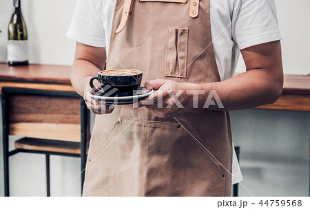 asian male barista wear apron holding coffee cup asian male barista wear apron holding coffee cup 44759568