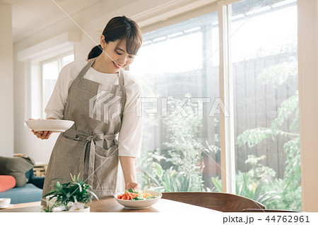 テーブルに食事を運ぶ若い主婦 日本人女性 44762961