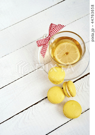 top view of delicious and sweet macaroons and hot lemon tea on an old wooden table top view of delicious and sweet macaroons and hot lemon tea on an old wooden table 44763658