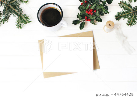 Christmas composition. Cup of coffee, holly berries, fir Christmas tree branches and silk ribbon on Christmas composition. Cup of coffee, holly berries, fir Christmas tree branches and silk ribbon on 44764429