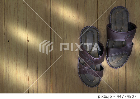 Brown leather slippers on wood background Brown leather slippers on wood background 44774807