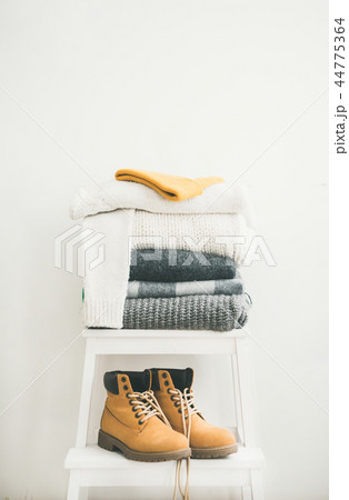 Pile of warm sweaters and blankets, cap and boots 44775364