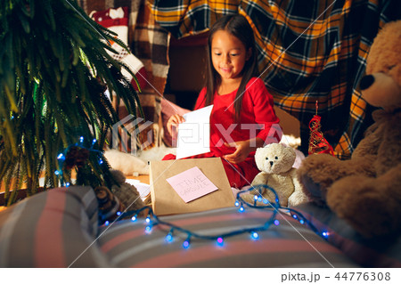 Merry Christmas and Happy Holidays. Cute little child girl writes the letter to Santa Claus near Merry Christmas and Happy Holidays. Cute little child girl writes the letter to Santa Claus near 44776308