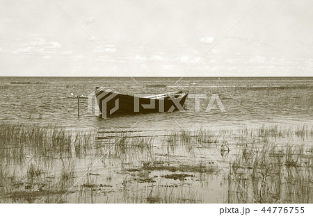 Wooden boat near the lake bank Wooden boat near the lake bank 44776755