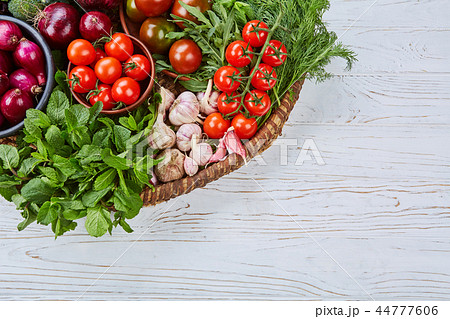 Vegetables assorted in a large basket on a white desk 44777606