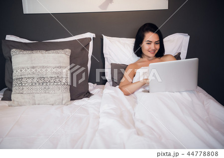 Portrait of beautiful young woman with laptop on bed 44778808