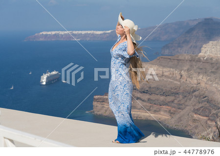 young woman in a white and blue dress enjoys a walk around Santorini young woman in a white and blue dress enjoys a walk around Santorini 44778976