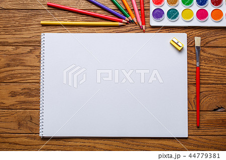 On the table there is an album for painting, paint and pencils 44779381