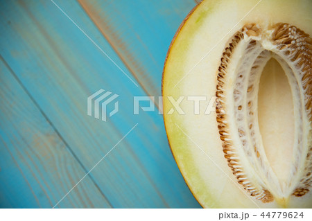 half ripe melon on a rustic, blue wooden background 44779624