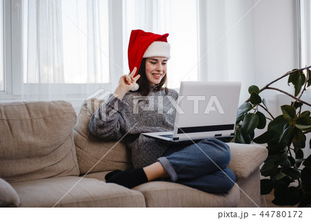 Woman showing victory gesture during video call 44780172