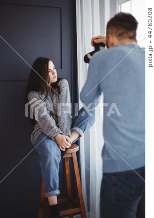 Photographer taking pictures of woman in studio Photographer taking pictures of woman in studio 44780208