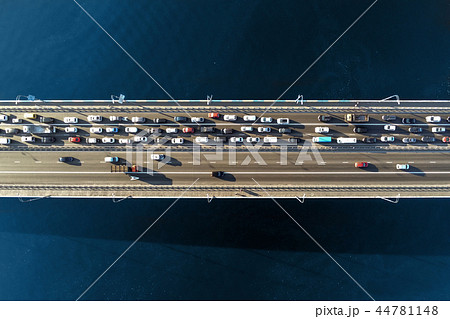 Aerial view of road bridge across river with heavy traffic jam in one direction. Rush hour with mash Aerial view of road bridge across river with heavy traffic jam in one direction. Rush hour with mash 44781148