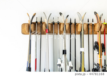 Lot of ski hanged on customized wooden wall mount at garage for seasonal storage. Extreme winter 44781168