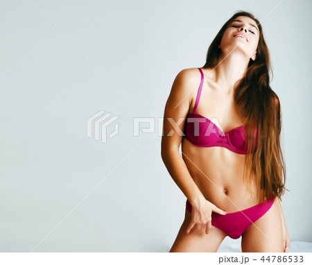 young pretty female in pink underwear in her bed smiling confide 44786533