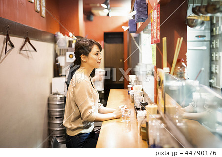一人でラーメンを楽しむ女性 44790176