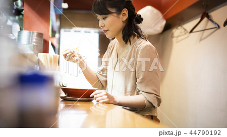 一人でラーメンを楽しむ女性 44790192
