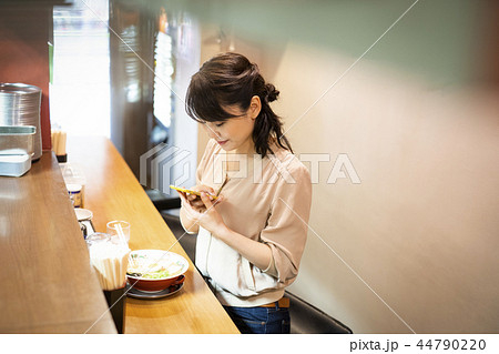 一人でラーメンを楽しむ女性 44790220
