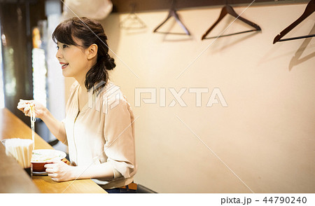 一人でラーメンを楽しむ女性 44790240