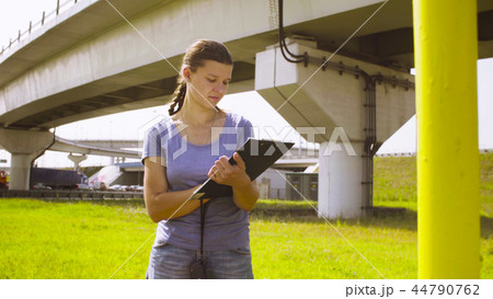 Woman ecologist standing near higway and writing something Woman ecologist standing near higway and writing something 44790762