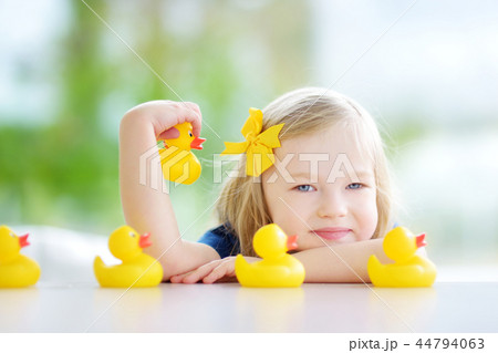 Cute little girl playing with rubber ducklings at home 44794063