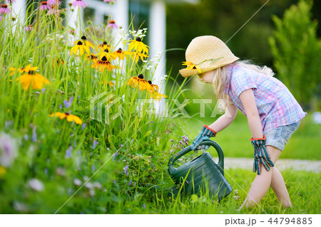 Cute little girl watering flowers in the garden  44794885