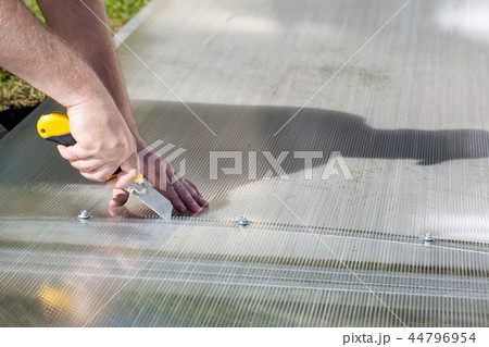 Worker cutting polycarbonate with knife Worker cutting polycarbonate with knife 44796954