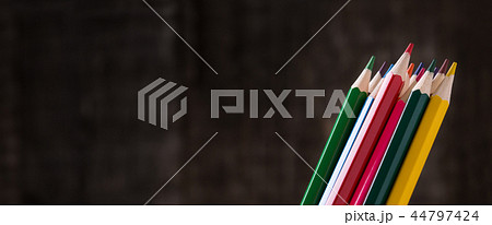 Colour pencils in holder on wooden background 44797424