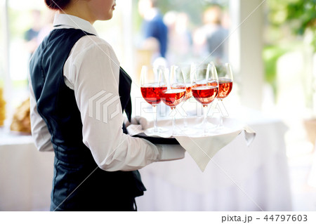 Waitress with dish of champagne and wine glasses 44797603