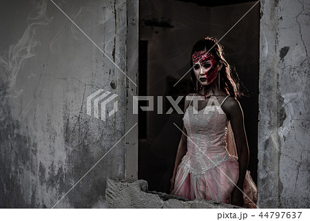 Female zombie corpse standing in front of wall Female zombie corpse standing in front of wall 44797637
