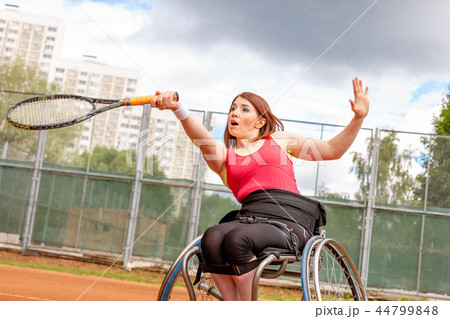 Disabled young woman on wheelchair playing tennis on tennis court. Disabled young woman on wheelchair playing tennis on tennis court. 44799848