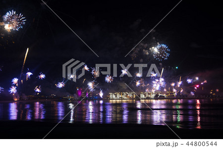 Festive firework over seaside water 44800544