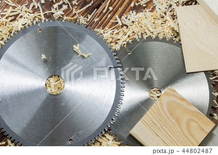 Two saw blades and pieces of wood on sawdust 44802487