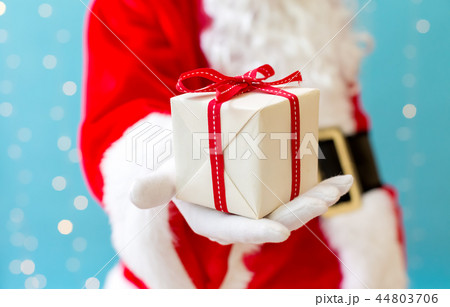 Santa holding a small Christmas gift 44803706