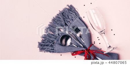 Champagne glass, cutlery and napkin on pink pastel background. Long banner format Champagne glass, cutlery and napkin on pink pastel background. Long banner format 44807065